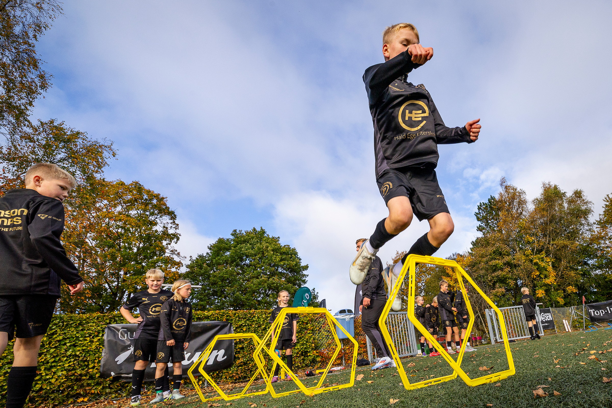 Dreng i Pimpongs Talentskoles spillesæt hopper over gule agility-ringe